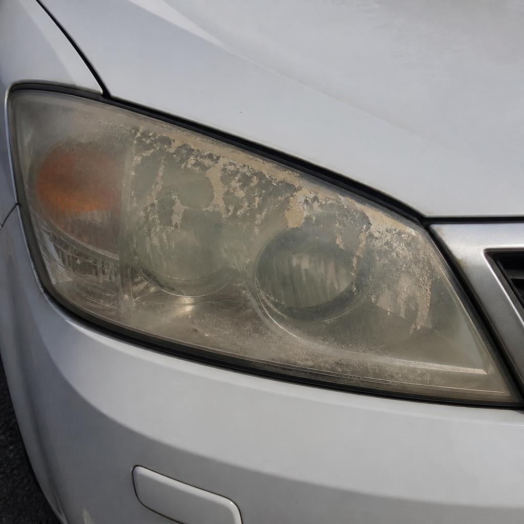 White sedan headlight before restoration